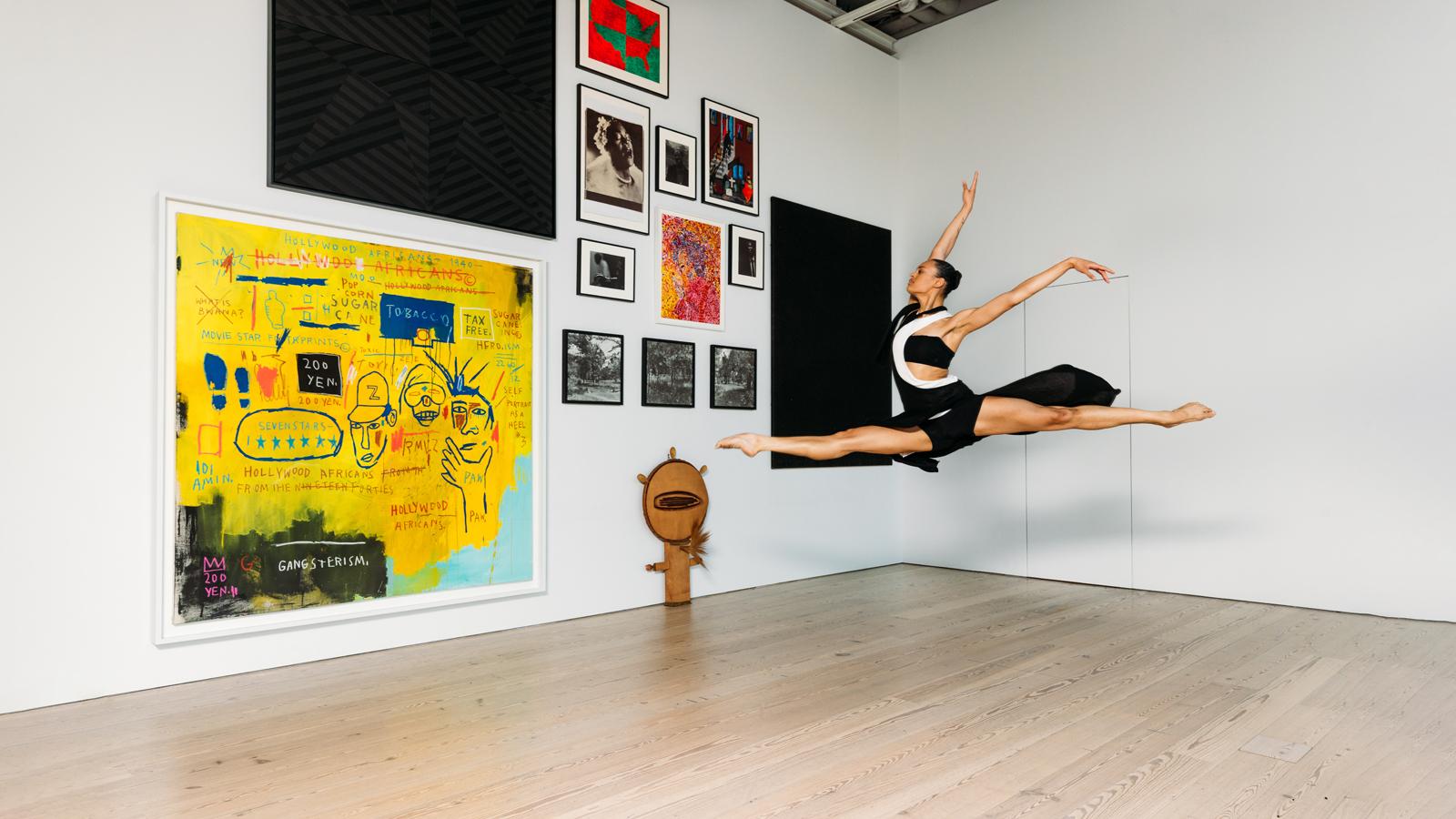 A dancer leaping inside an art museum.