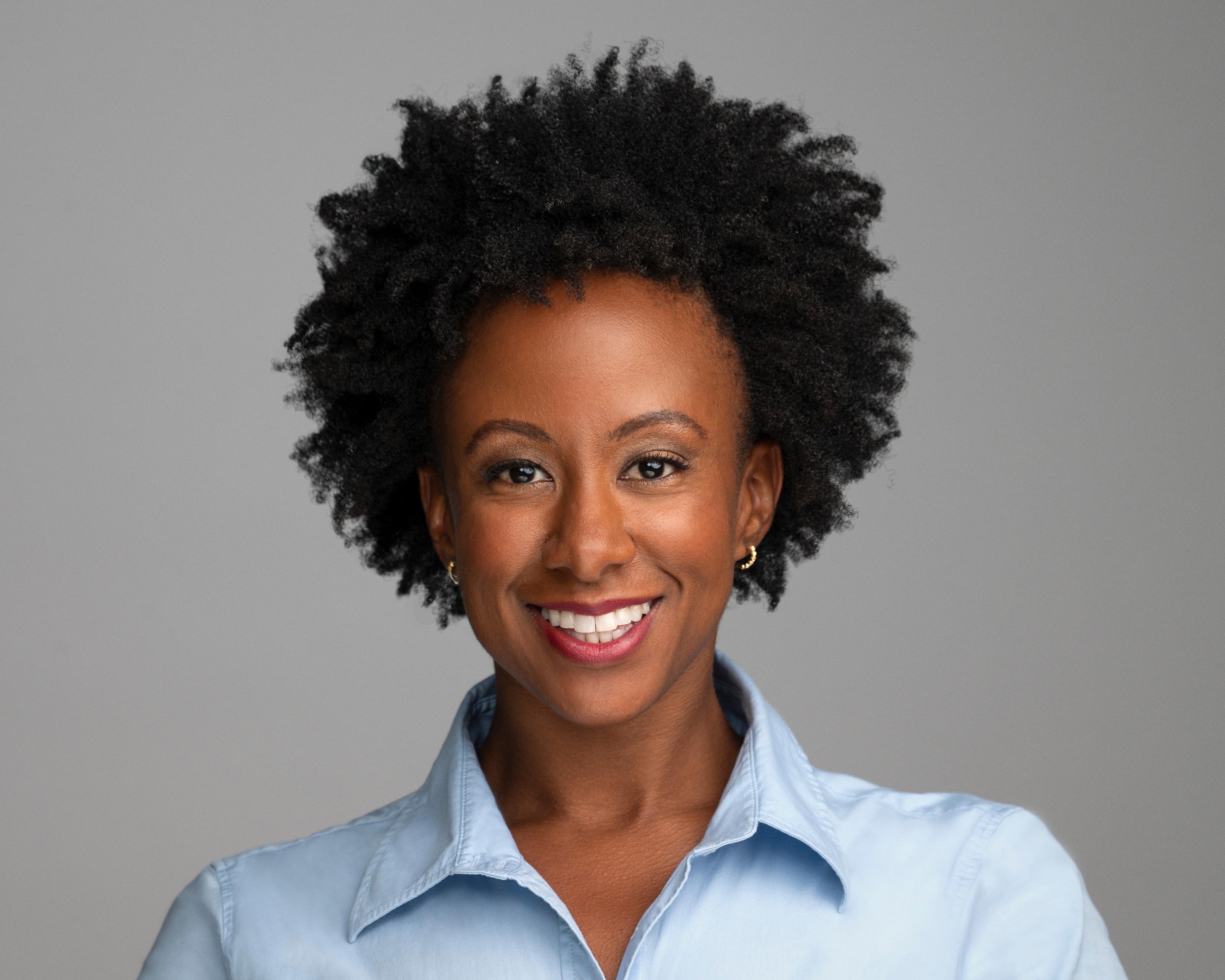 A headshot of Dr. Rachel McCaulsky, a black women with short hair wearing a blue shirt