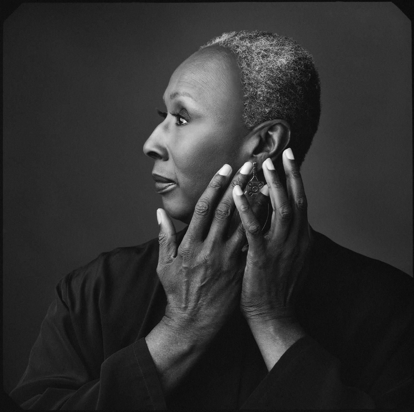 Portrait of Judith Jamison facing profile with both hands held up to her face.