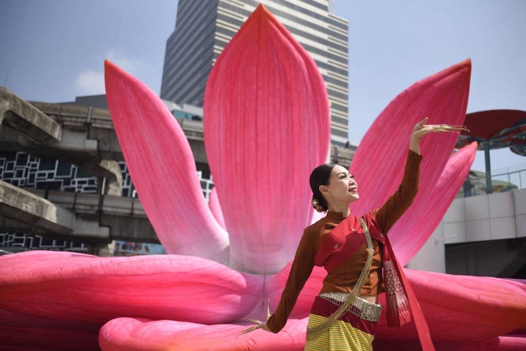 Dancer Waewdao Sirisook performing Fawn Leb with bronze nails in front of a large pink lotus statue